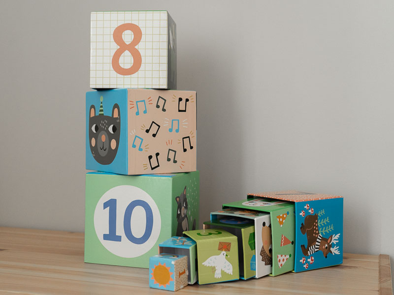 Des cubes en carton avec motif et chiffre sur les différentes faces à empiler les unes sur les autrs