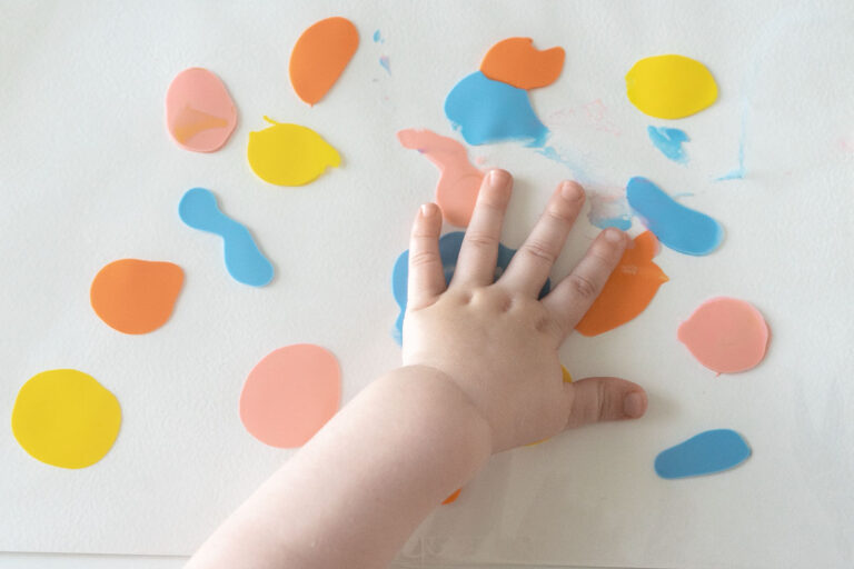 Main de bébé qui joue avec de la peinture propre